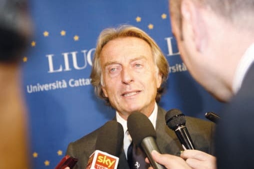 Primo piano di un uomo dai capelli chiari che sorride, circondato da microfoni; dietro di lui un pannello blu con il logo LIUC Università Cattaneo.